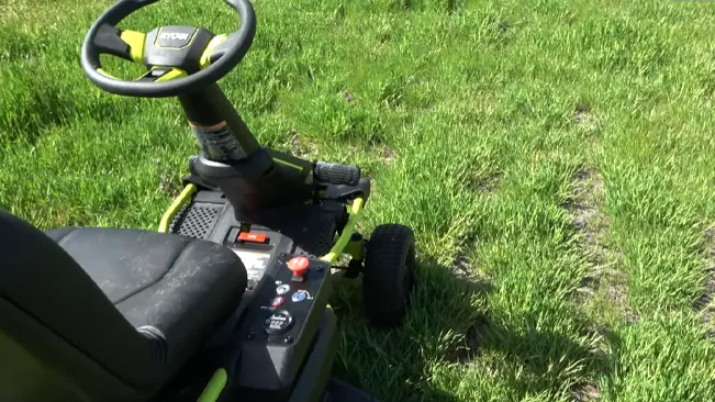 Driver’s perspective of a riding lawn mower on an unevenly grown grassy field