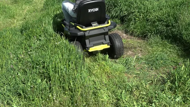 Ryobi lawnmower on an overgrown grassy lawn, contrasting mowed and unmowed sections