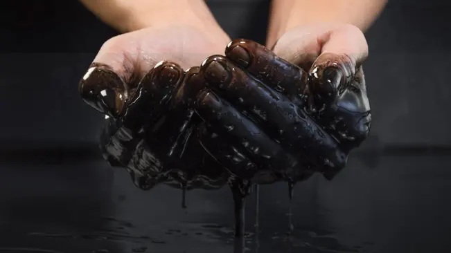 Hands covered in black oil
