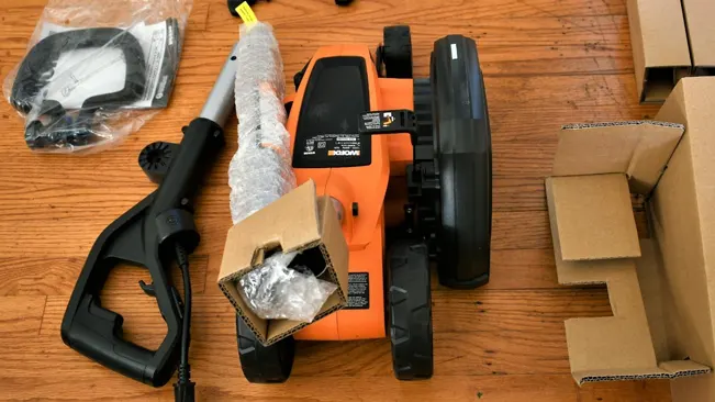 Disassembled Lawn Edger with packaging materials on a wooden floor