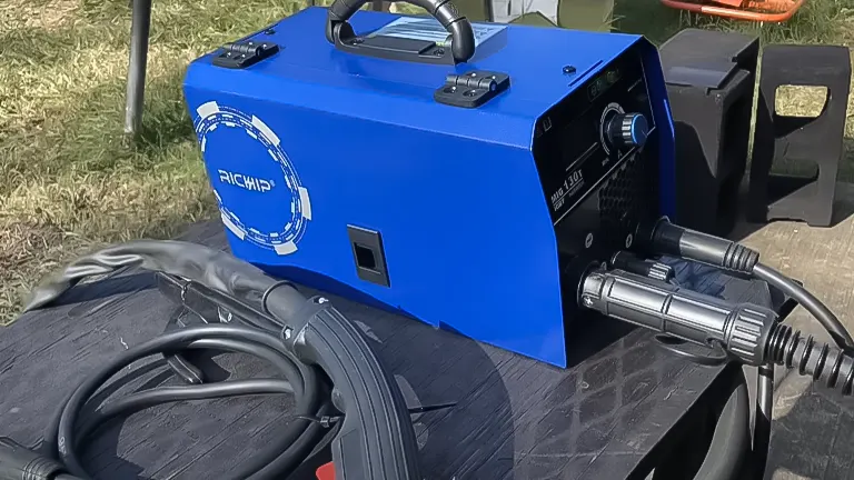 Blue Riland 130A Flux Core 3-in-1 welder machine placed on top of a large black tire