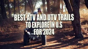 Two people riding an ATV through a wooded trail with sunlight filtering through the trees.