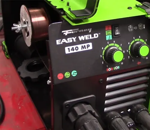 Partial view of a Forney Easy Weld 140 MP welder's control panel and wire feed with green housing.