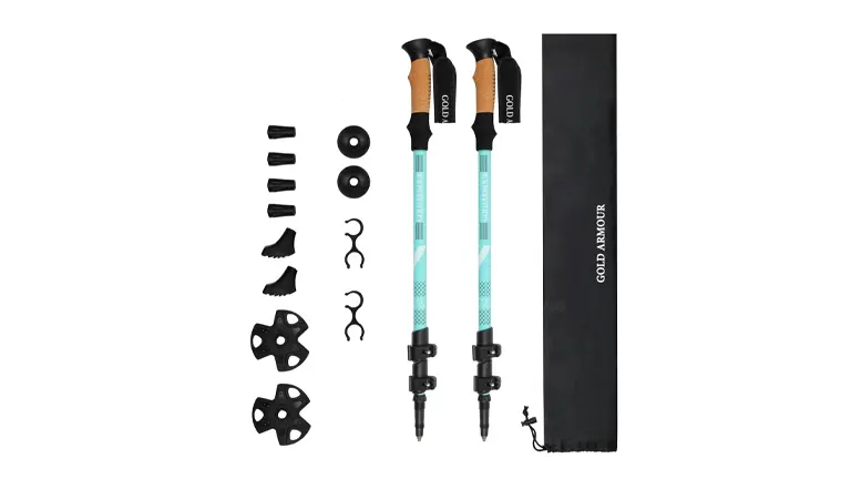A pair of teal and black trekking poles with ergonomic cork grips next to various accessories, including mud and snow baskets, and a carrying case labeled 'GOLD ARMOUR