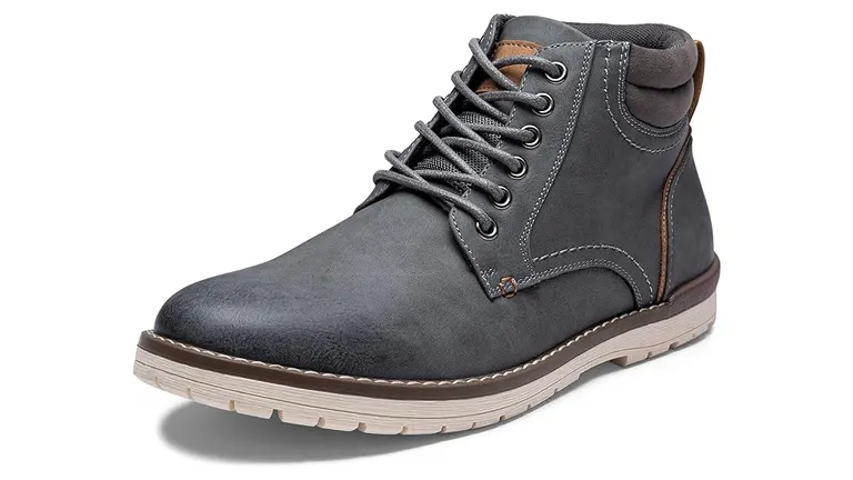 A single charcoal gray chukka boot with light brown lining, detailed stitching, a tan sole, and gray laces, on a white background.


