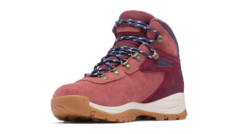 A single dusty rose-colored hiking boot with navy blue accents, featuring patterned laces, metal eyelets, and a chunky tan sole, displayed against a white background.
