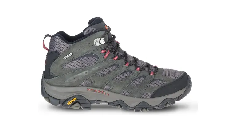 A single gray Merrell hiking boot with mesh inserts and red detailing, equipped with a Vibram sole for enhanced traction, shown against a white background.
