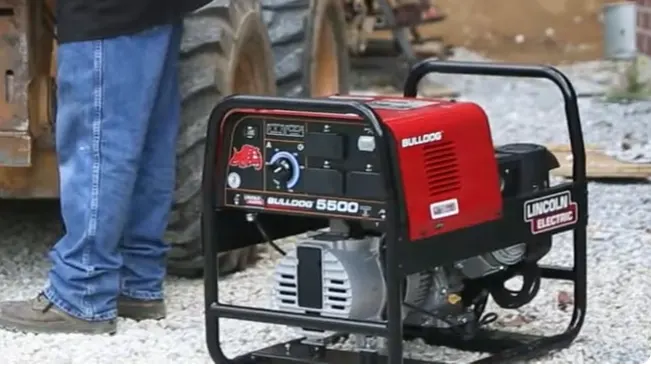 Lincoln Electric Bulldog 5500 welder generator on a construction site with a person in the background.