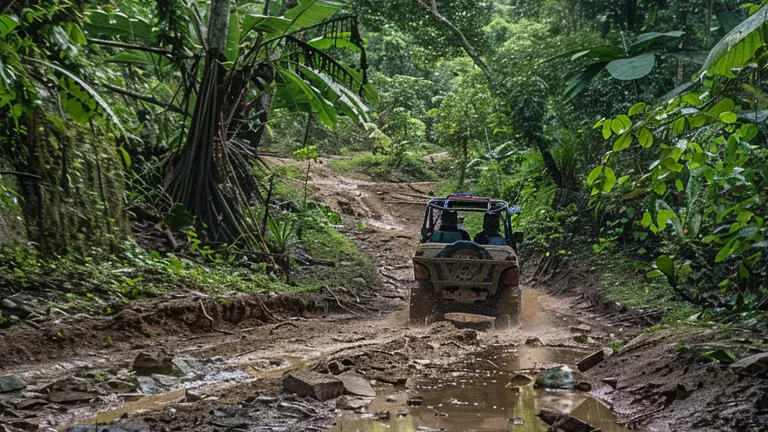 An off-road vehicle traversing a muddy and rocky jungle path with lush green foliage on both sides.
