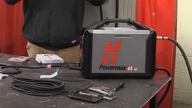 Hypertherm Powermax45 XP plasma cutting system on a workbench with cables and tools, workshop setting.