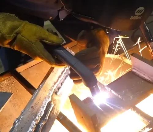 Close-up of metal cutting with sparks using Hypertherm Powermax45 XP Hand System, by a person in protective gear.