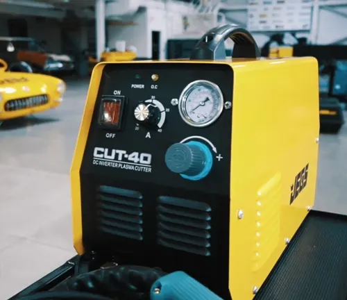 JEGS CUT-40 DC Inverter Plasma Cutter with pressure gauge and controls, in a garage with a classic car background.