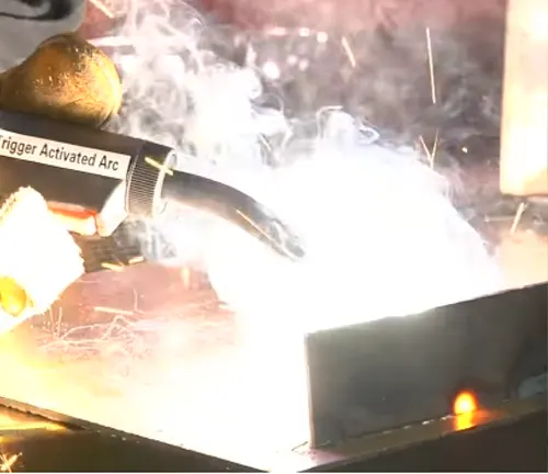 Bright arc welding sparks from a flux-cored welder.