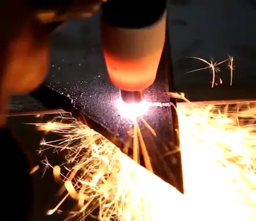 Intense plasma cutting action with bright sparks and molten metal, showcasing the JEGS Plasma Cutter's precision.