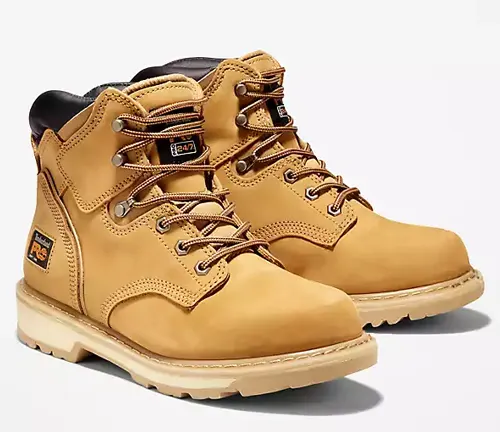 Pair of tan welding boots with black padded collars and contrast stitching, 2024 series.