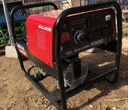 Outdoor view of a red Lincoln Electric Bulldog 5500 AC Welder on a black frame, displaying control panel and branding.
