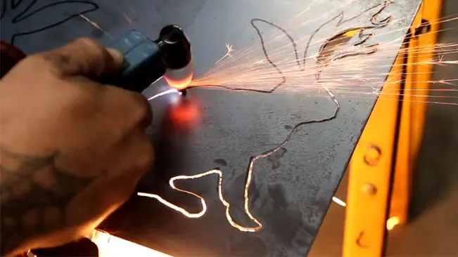 Hand guiding a JEGS plasma cutter torch through metal, with glowing cut lines and flying sparks.