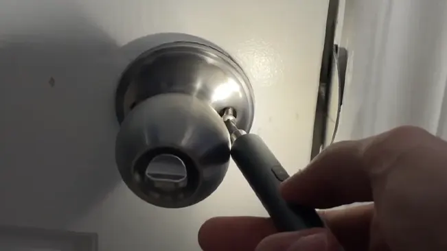 Using pen-style electric screwdriver with LED on door knob.