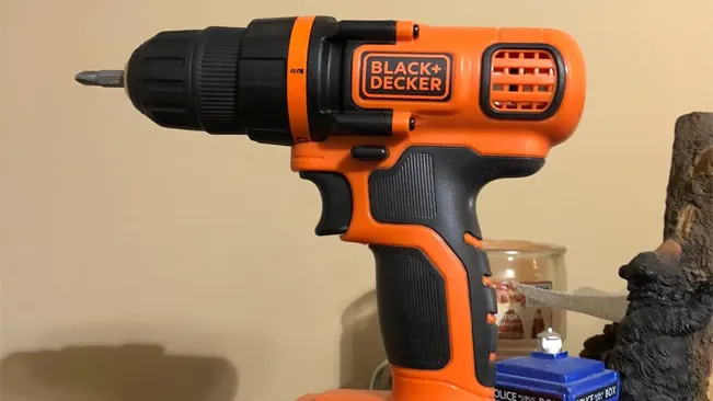 Orange and black BLACK+DECKER cordless drill with bit, against a plain background