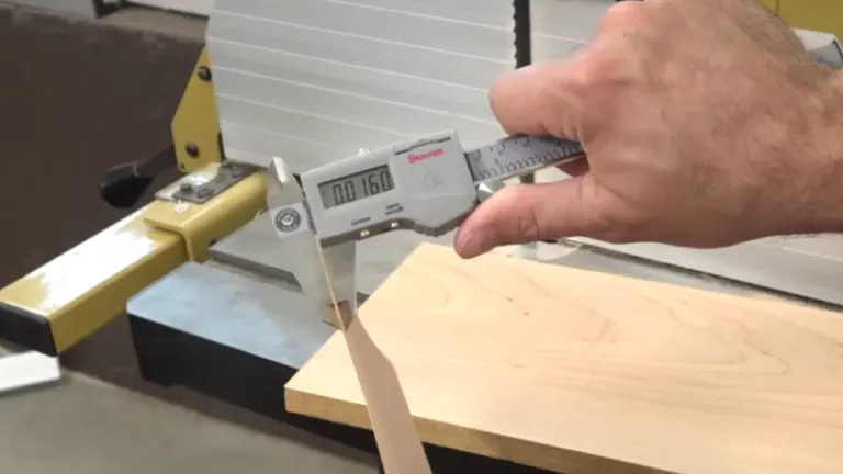 Person measuring the wood plank cutted in the bandsaw