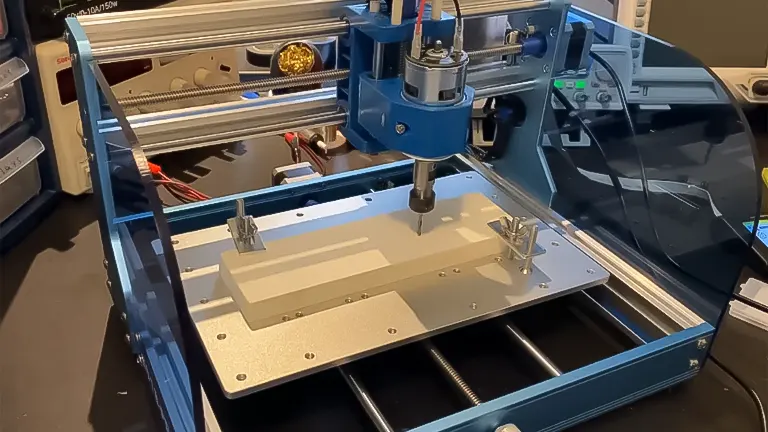 A CNC machine for woodworking with a milling bit positioned above a clamped piece of wood