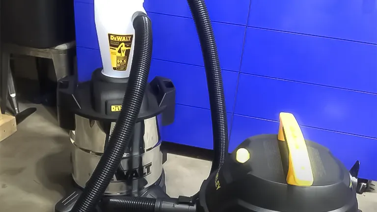 DEWALT dust collector and yellow-handled floor tool in a workshop with blue walls
