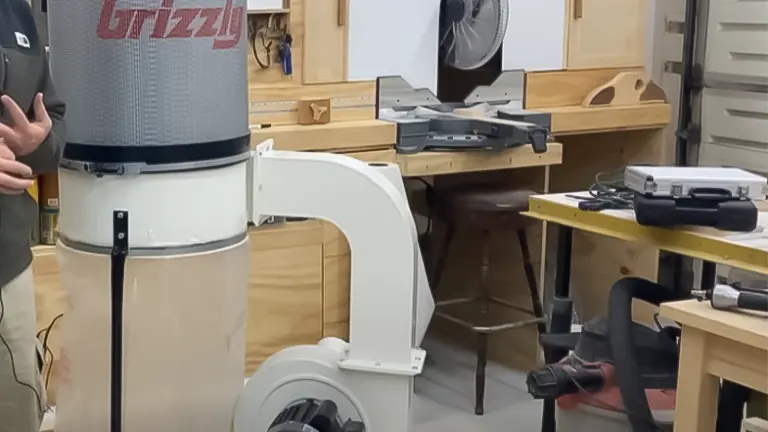 Grizzly dust collector with a person partially visible in a well-equipped woodworking shop