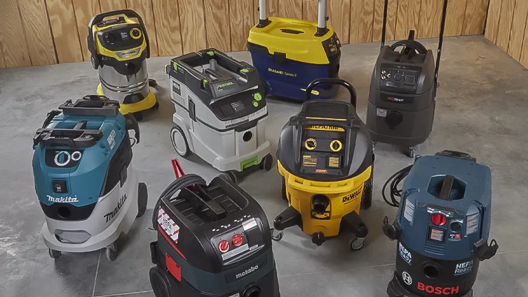 A selection of various branded dust collectors on a concrete floor