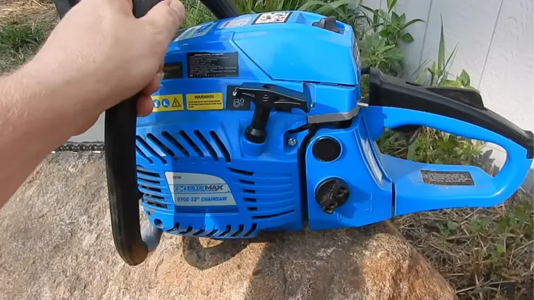 Person holding Blue Max 57cc Chainsaw sitting on the rock