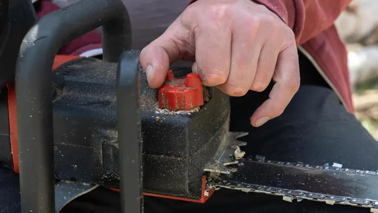 Person turning the Chainsaw Bar Oil cap open