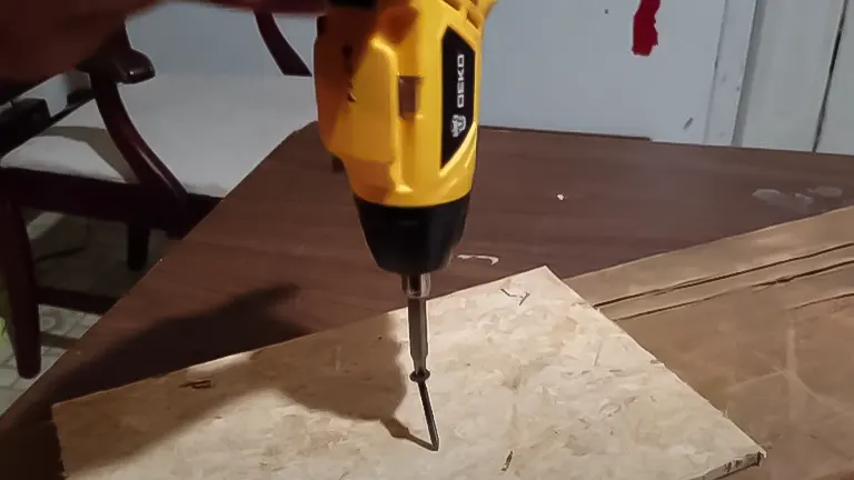 DEKOPRO 3.6V electric screwdriver in action, driving a screw into wood