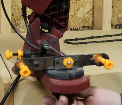 Person adjusting the knob below of the Harbor Freight Chainsaw Sharpener