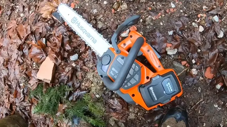 Husqvarna T540i XP Chainsaw  laying on the wet leaves