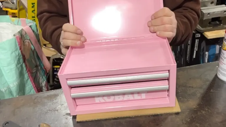 Person holding the top cover of the Kobalt Mini Pink Drawer Steel Tool Box sitting on the desk