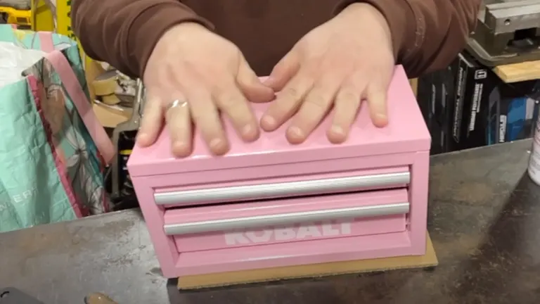 Person putting hands on the top of the Kobalt Mini Pink Drawer Steel Tool Box