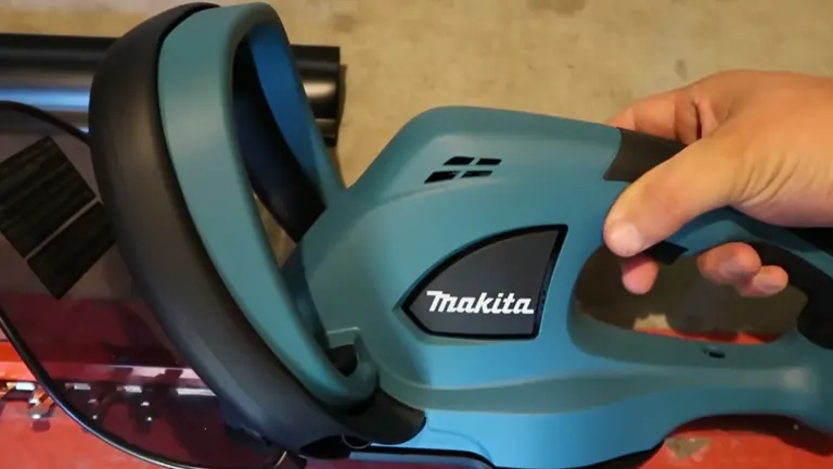Person using holding the grip of Makita 18V LXT Cordless Hedge Trimmer