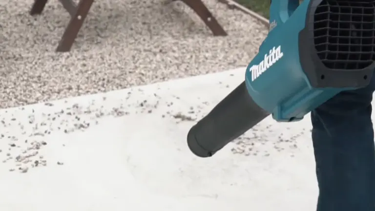 Person blowing pebbles in the backyard using Makita 18V LXT Blower