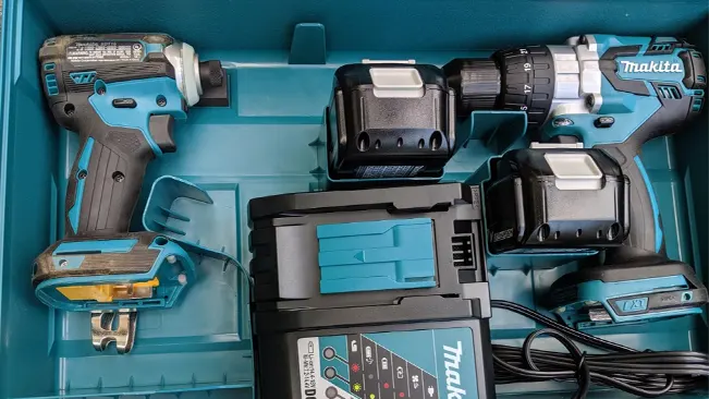 Makita power tool kit in case with a hammer driver-drill, impact driver, batteries, and charger.