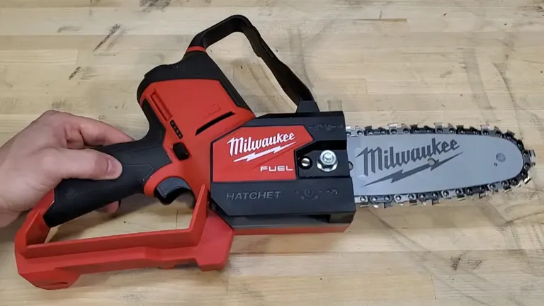 Person holding Milwaukee M12 FUEL Pruning Saw in the table 