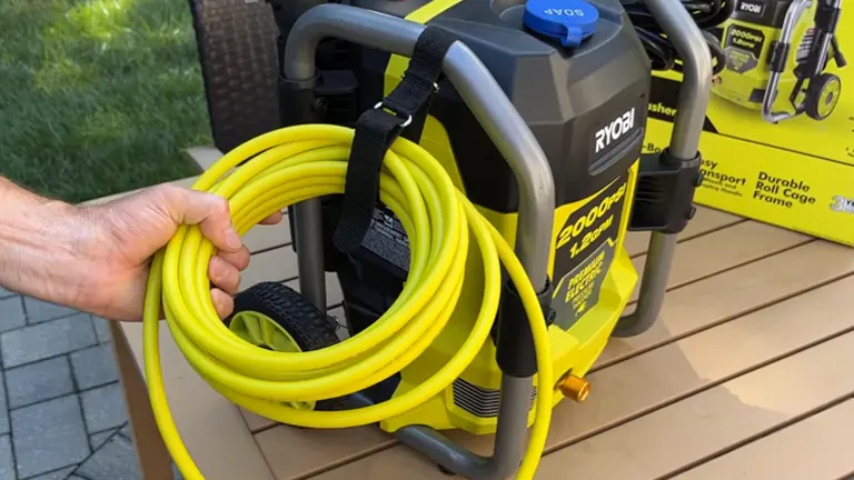 Person holding the hose of the RYOBI 2000 PSI Pressure Washer sitting in the wood deck