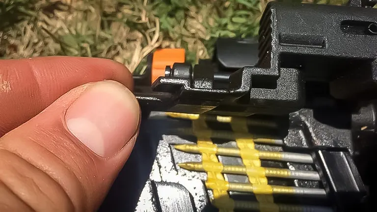 Close-up of a person's thumb pressing the safety tip of a Ridgid R350CHD framing nailer