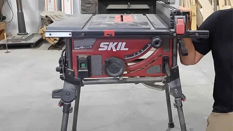 Person adjusting a SKIL 15 Amp 10 Inch Portable Jobsite Table Saw
