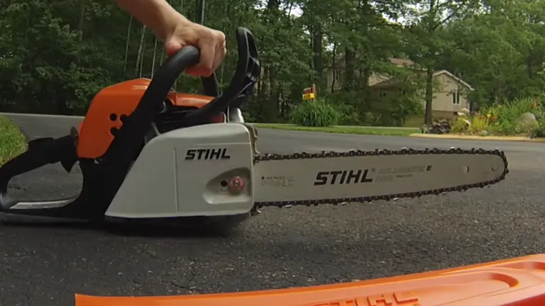 Person holding STIHL MS 171 Chainsaw laying in the road with chain cover