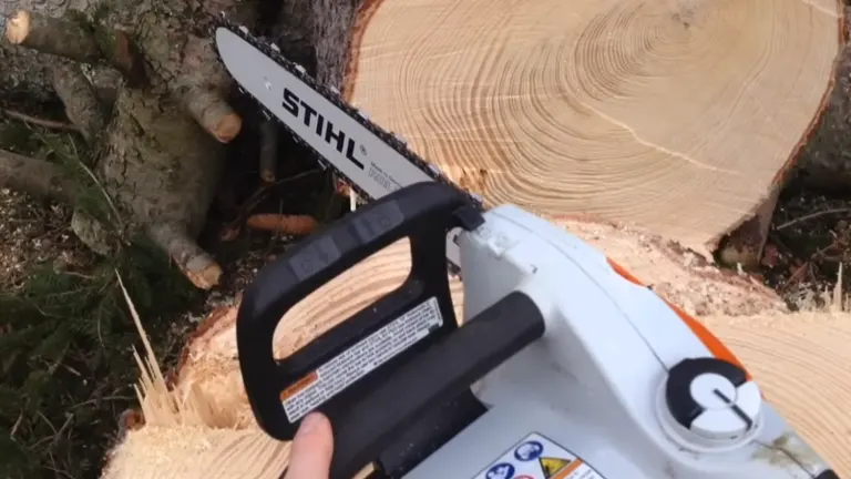 Person touching the STIHL MSE 170 C-BQ sitting on the spruce trunk