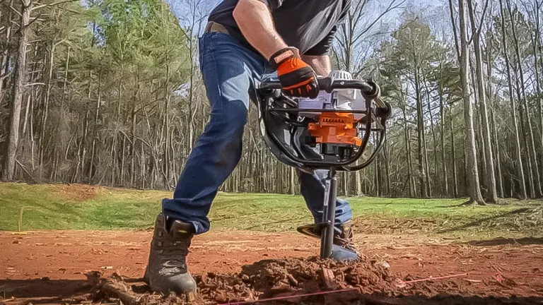 Person operating a Stihl BT 131 Earth Auger in soil