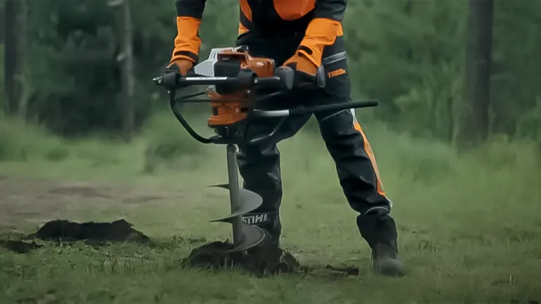Individual operating a Stihl BT 131 Earth Auger on grassy terrain