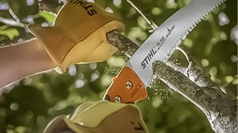 Person wearing gloves using a Stihl PS 90 arboriculture saw to cut a branch