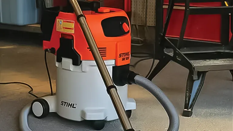 Orange and white Stihl SE 122 vacuum cleaner on a workshop floor