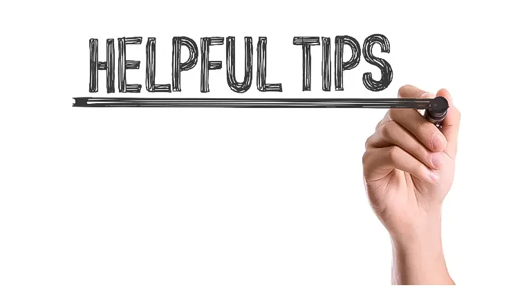 A hand writing the words 'HELPFUL TIPS' with a marker on a clear surface