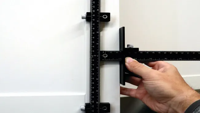 Person using a vernier caliper to measure the thickness of a white door.
